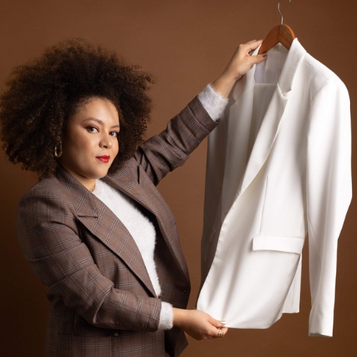 Imagem da consultora segurando um blazer branco